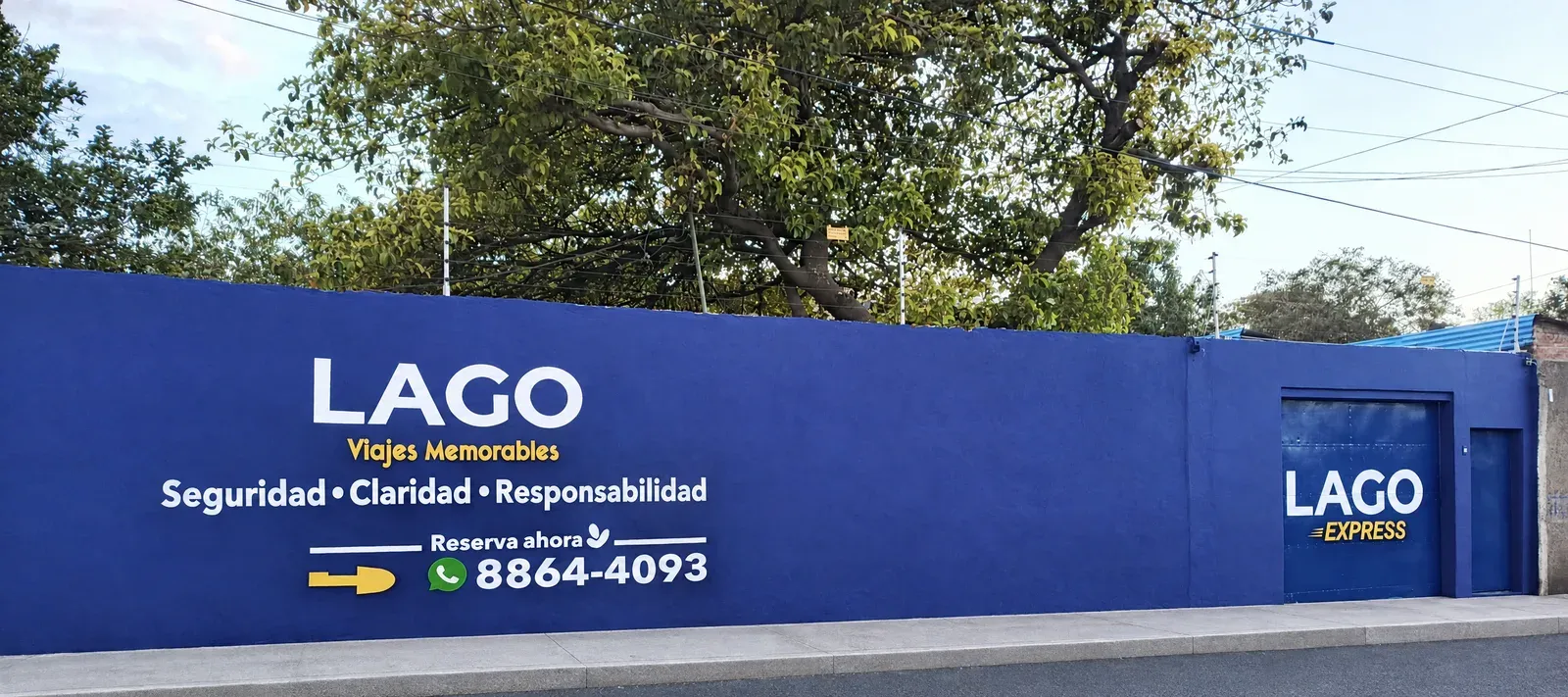 LAGO Rent a Car entrance on Carretera Norte, Managua: blue wall with the sign and WhatsApp 8864-4093
